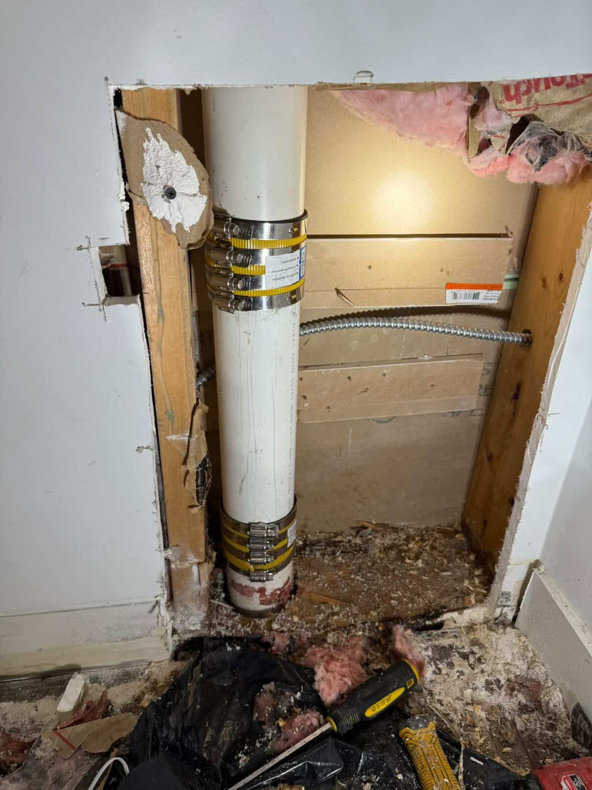 PVC stack pipe with stainless shielded couplings in a wall cavity