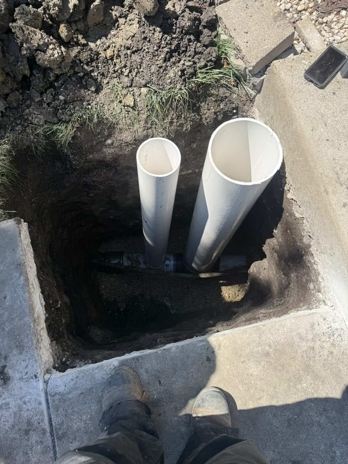 Dual PVC sewer line risers in excavated trench